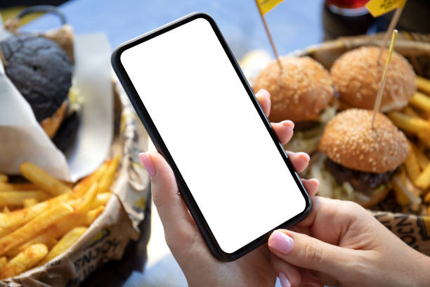 téléphone femelle de fixation de mains avec le fond d’écran d’isolement des hamburgers - electronic organizer palmtop women personal data assistant photos et images de collection