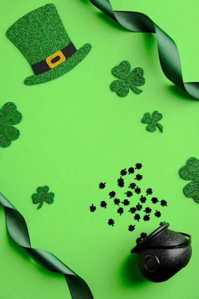 istock St Patrick's Day flat lay composition. Saint Patricks Day green background with leprechaun hat, shamrock leaves, pot of gold, ribbon. Top view, overhead. 1303811943