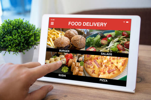 istock male hand selects menu computer tablet with food delivery application 1303811951