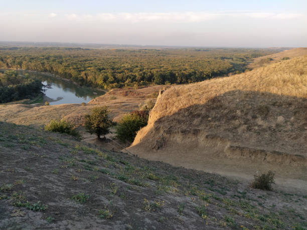 istock Sunset valley wirh a hills and trees and river below 1303812199