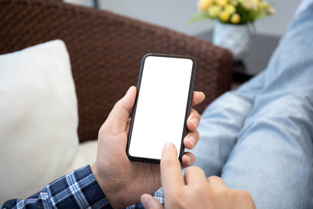 istock male hands holding phone with isolated screen on background room 1303812521