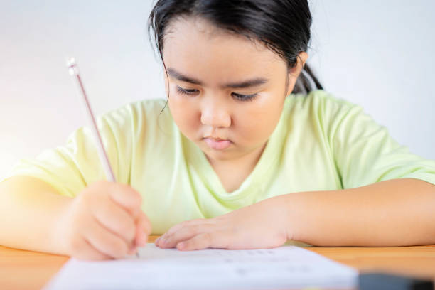 istock An Asian girl is doing her homework, practice doing skill-enhancing exercises, Back to school concept. 1303813226
