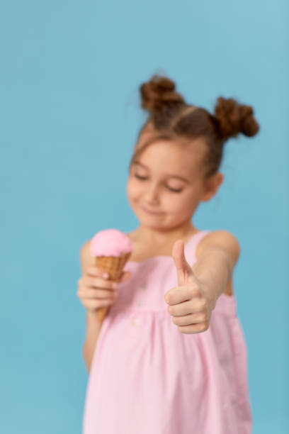 istock smiling little girl holding vanilla ice cream 1303814908