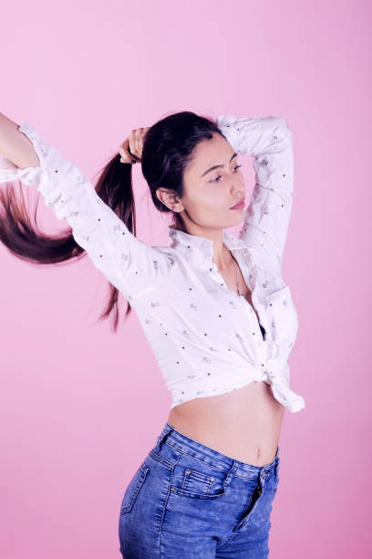 istock woman with white top on pink background 1303815863