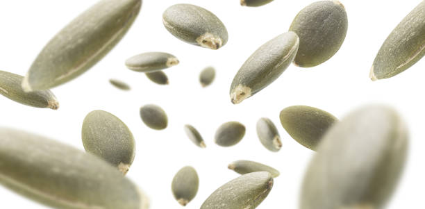 istock Peeled pumpkin seeds levitate on a white background 1303817113