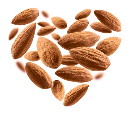 Almond nuts in the shape of a heart on a white background.