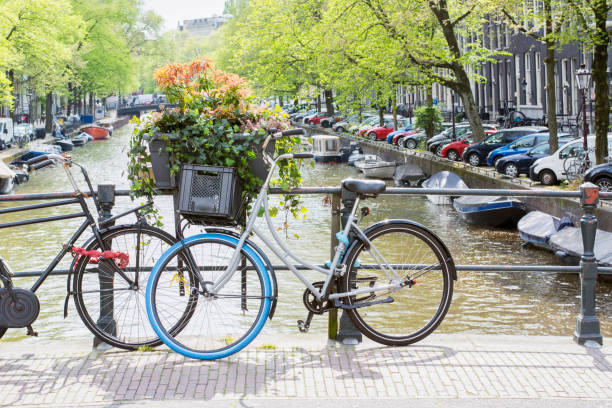 istock Two Dutch bikes are standing on the bridge on the spring day in Amsterdam. Typical spring Dutch landscape with standing bikes 1303817405