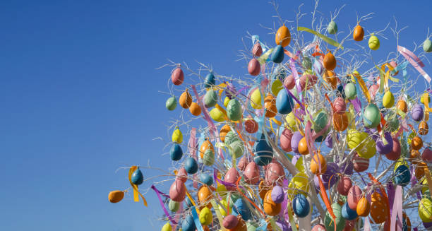 Holiday street decoration with easter eggs tree and ribbon branch spring sunny blue sky background. Moscow