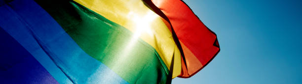 istock rainbow flag waving on the sky, web banner 1303818540