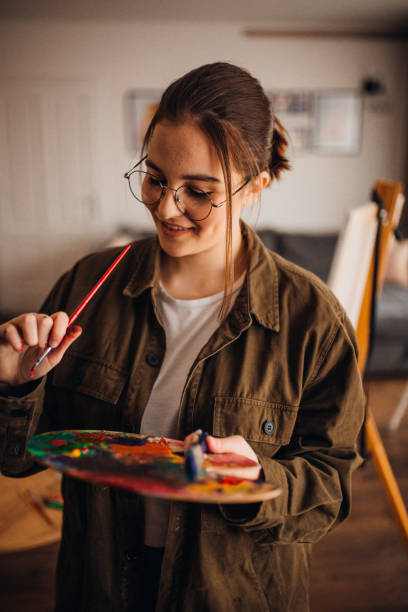 istock Girl painting on canvas 1303822164