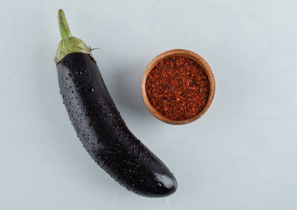 istock Fresh raw eggplant with red pepper on white background 1303823492