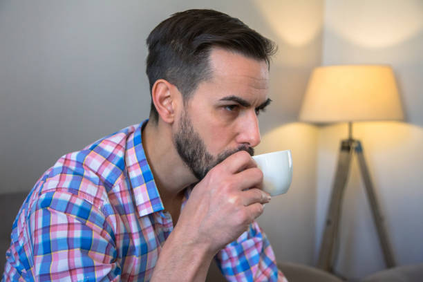 istock A man with a black beard is sitting in a cafe and drinking coffee and working on a computer 1303823574