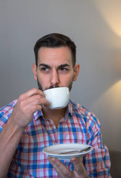 istock A man with a black beard is sitting in a cafe and drinking coffee and working on a computer 1303823609