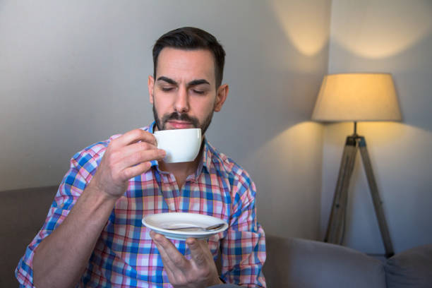 istock A man with a black beard is sitting in a cafe and drinking coffee and working on a computer 1303823777