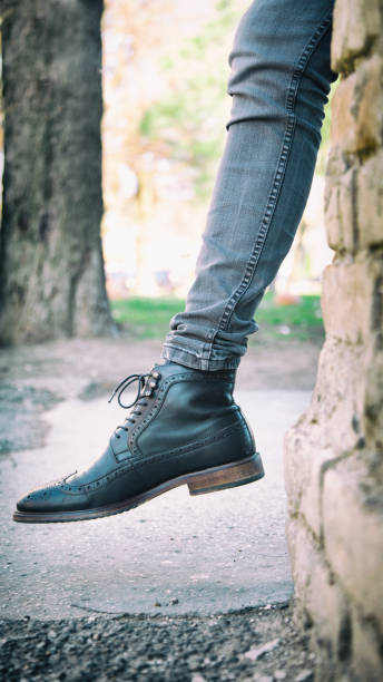 istock Man's leg with black shoe outdoor 1303824579