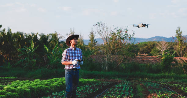 istock asian farmer controlling smart drone which flying above his farm 1303825049