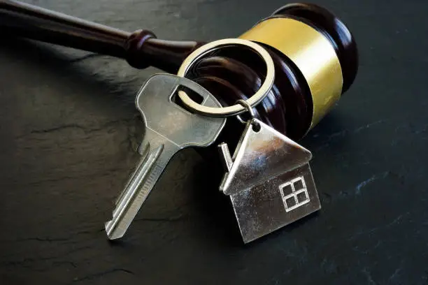 Photo of Property litigation and Disputes concept. Key for home and gavel.