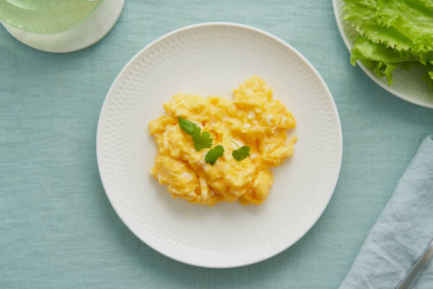 Scrambled eggs, omelette. Breakfast with pan-fried eggs. Texture of omelet on white plate stock photo