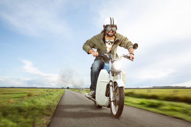istock Funny biker riding a moped with his dog 1303827853