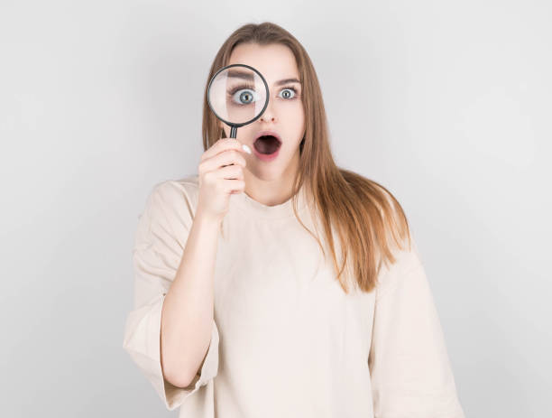 istock Shocked woman looking through a magnifying glass 1303829887