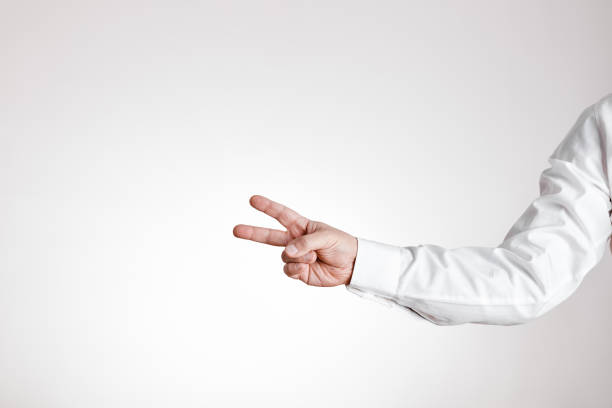 istock Businessman hand makes victory gesture on white background 1303831621