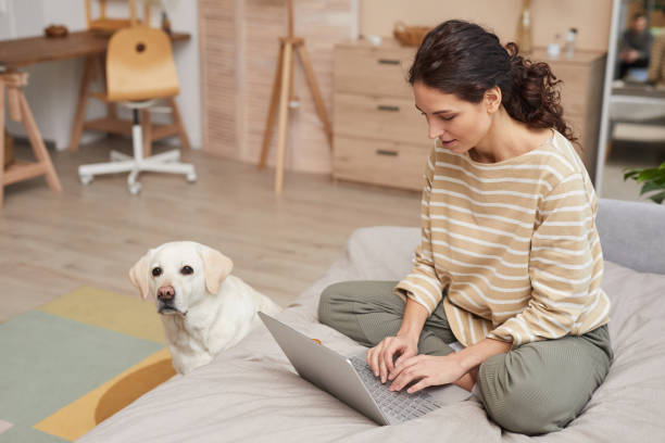 istock Young Woman Working from Home with Dog 1303834012