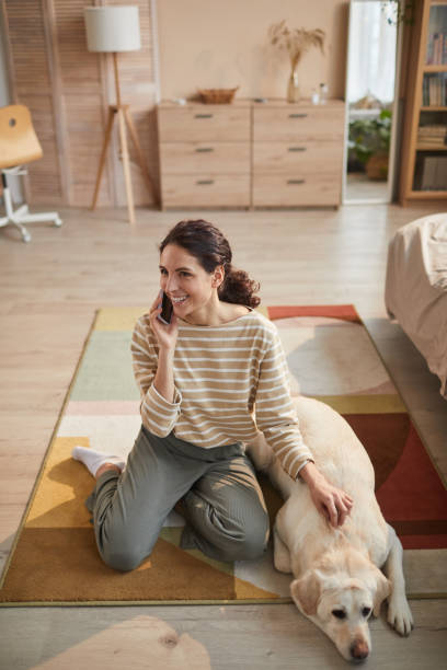 istock Young Woman with Dog at Home 1303834046