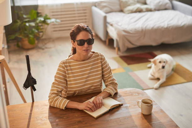 istock Young Blind Woman Reading Book at Home 1303834099
