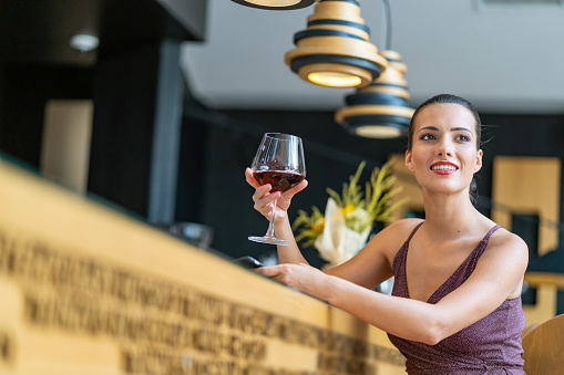Elegant woman drinking wine in restaurant