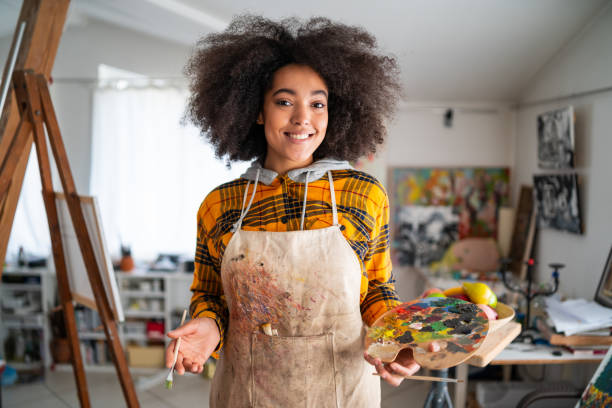istock Afro Female fine artists drawing in studio 1303834503
