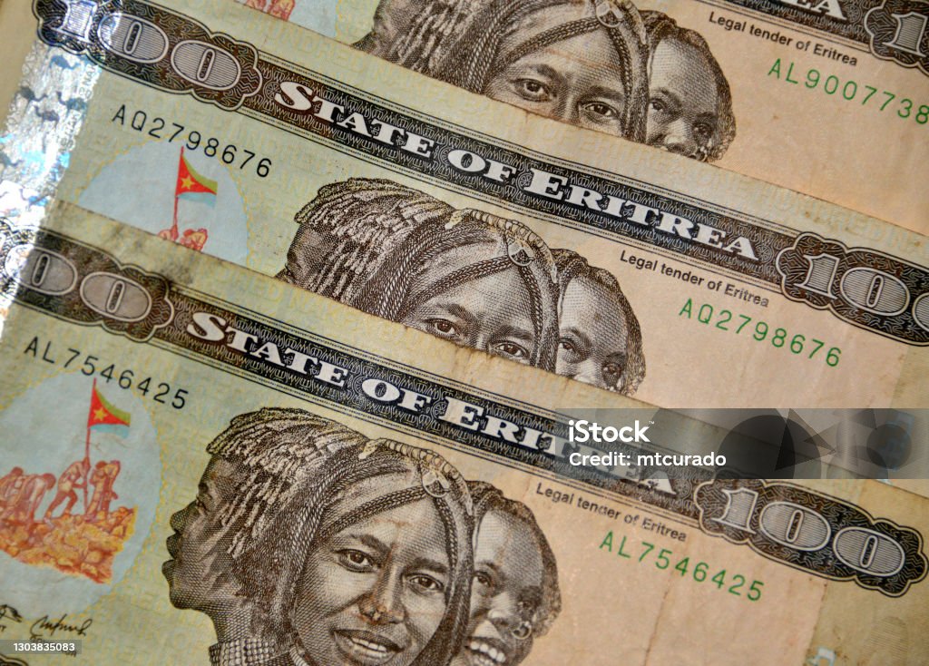Eritrean nakfa bank notes - 100 ERN, triptych portrait of three women Asmara, Eritrea: partial image of Eritrean nakfa bank notes, currency of Eritrea, replaced the Ethiopian birr in 1997, pegged to the US dollar - named after the Eritrean town of Nakfa - 100 Nakfa notes display a triptych portrait of three young women of Eritrea's different nationalities and flag raising by soldiers - ISO 4217. Africa Stock Photo
