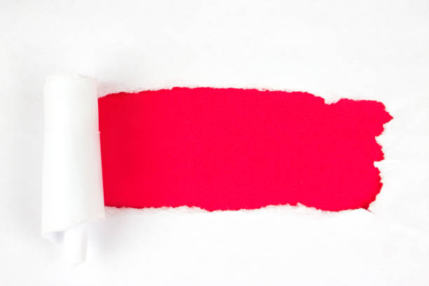 istock Red Hole in the white paper with torn sides, copy space 1303835553