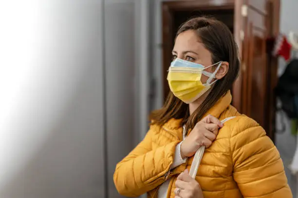 Photo of Young Woman wearing double face mask before going out