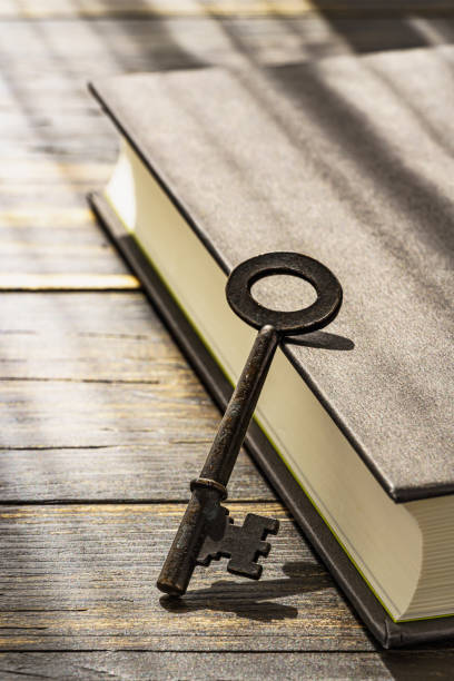 istock Vintage key and hardback book on wooden table 1303838456