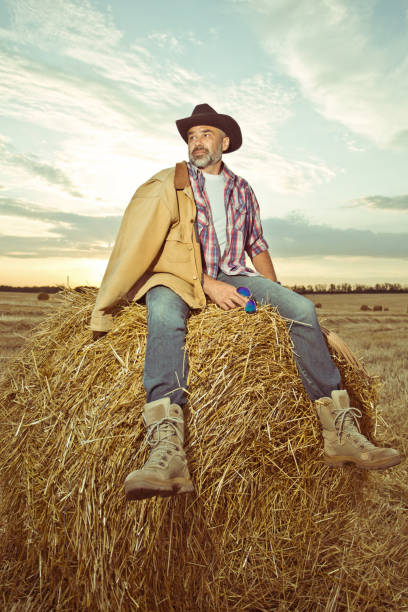 istock Farmer on the field wearing hat and work clothes 1303838881