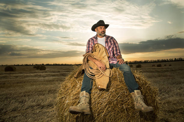 istock Farmer on the field wearing hat and work clothes 1303838884