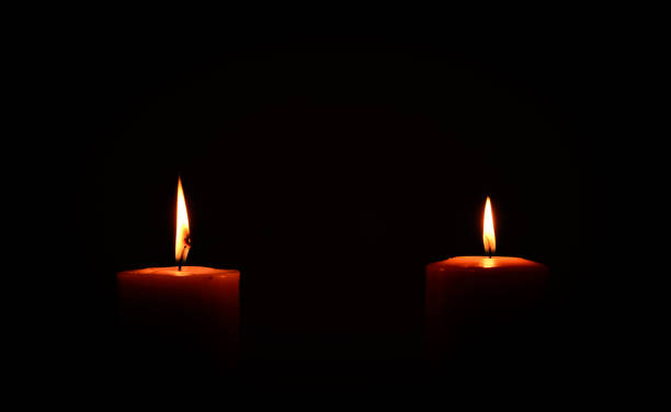 istock two candles burning in dark 1303840860