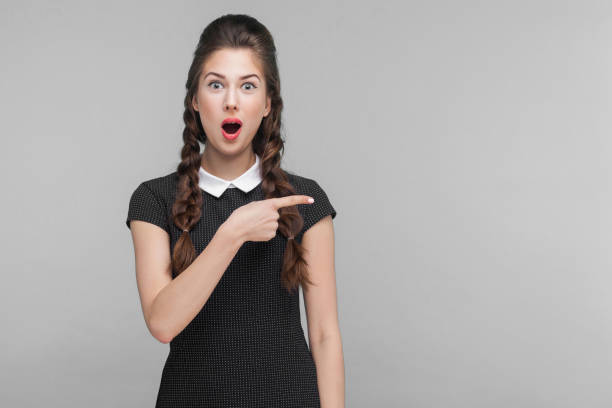 istock Amazement, wondered woman pointing finger right, at copy space. 1303841329