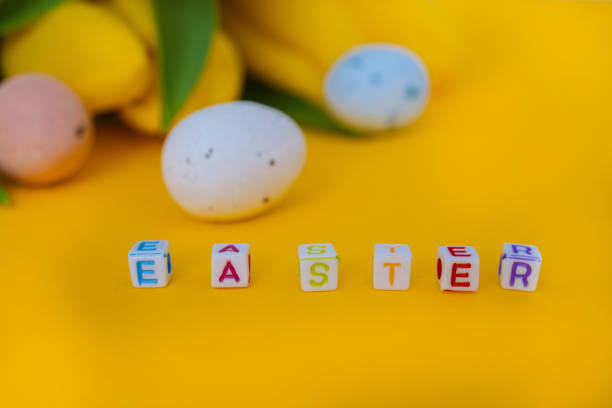 istock Easter holiday decorations on yellow background. Colorful easter painted speckled eggs in basket. Creative spring composition with Easter elements - flowers and eggs. Traditional Easter Celebrating 1303842267
