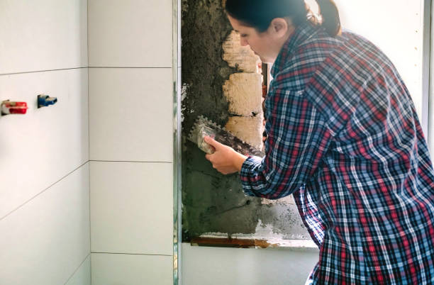 istock Female mason leveling cement with a trowel 1303842669