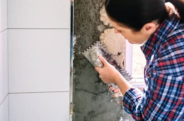 istock Female bricklayer leveling cement with a trowel 1303842681