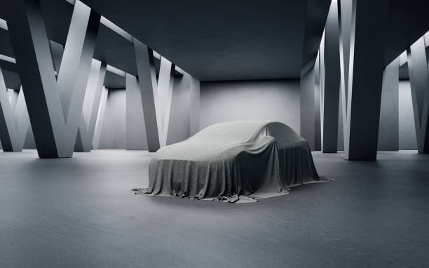 Abstract interior design for a modern showroom. 3D rendering of a new car covered with a cloth on the floor with concrete corridor background. dark showroom stock pictures, royalty-free photos & images