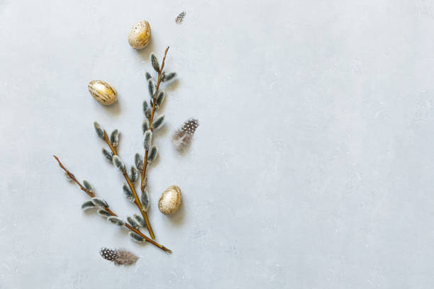 istock Happy Easter concept. Preparation for holiday. Golden decorated easter eggs willow feather on concrete stone grey background. Simple minimalism flat lay top view copy space 1303842967