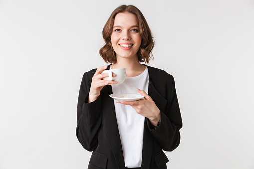 Photo of happy young woman standing isolated holding apple looking camera holding cup of coffee.