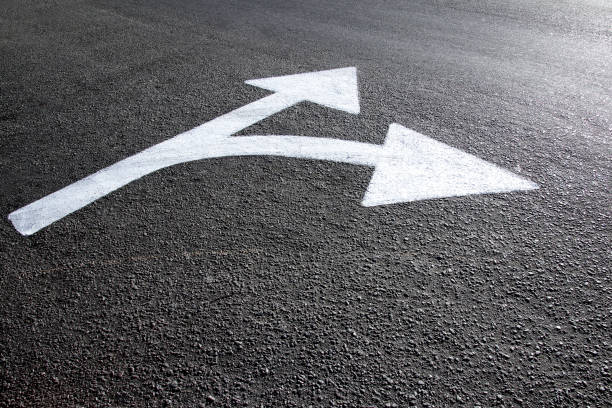 istock white directional arrows marked on the asphalt 1303844213