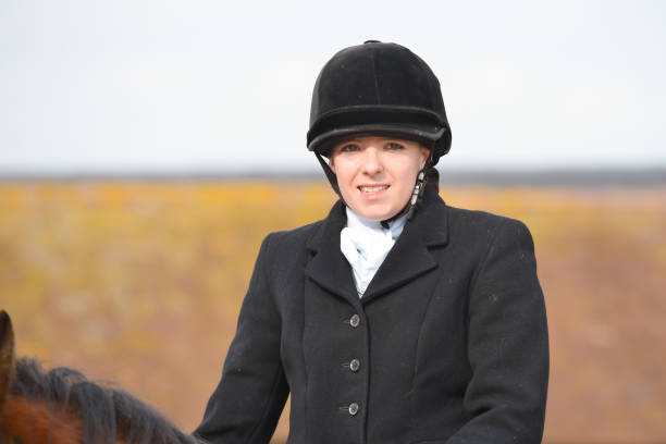 hermosa inteligentemente resultó joven jinete sonríe para la cámara mientras disfruta de un día a caballo en el campo inglés. - smartly fotografías e imágenes de stock