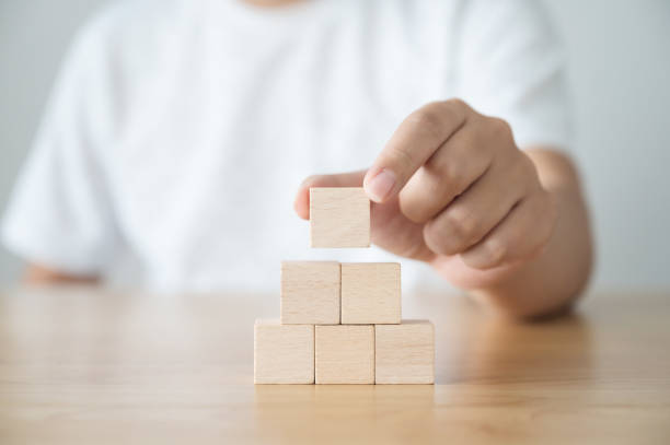 istock Hand arranging wood block stacking as step stair. Business concept for growth success process 1303850292