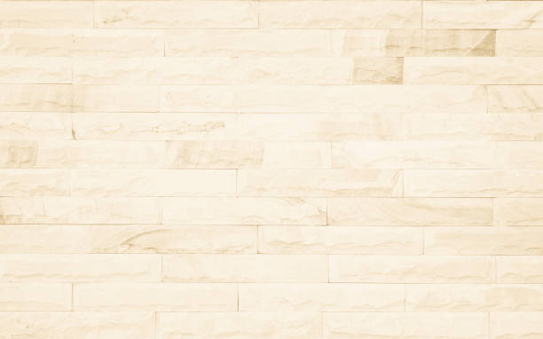 istock Empty background of wide cream brick wall texture. Beige old brown brick wall concrete or stone textured, wallpaper limestone abstract flooring/Grid uneven interior rock. Home decor design backdrop. 1303852561