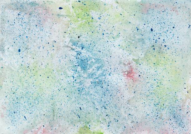 Watercolor wash background in blue, red and green with paint splashes in blue stock photo