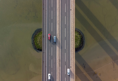 View from a drone looking down on traffic on a road bridge crossing a large river in Suffolk, UK